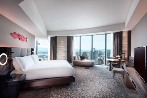 a hotel room with a bed and a large window at Conrad Osaka in Osaka