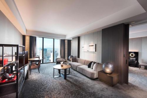 a living room with a couch and a table at Conrad Osaka in Osaka