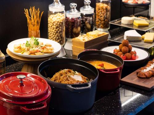 a buffet with various dishes of food on a counter at Conrad Osaka in Osaka