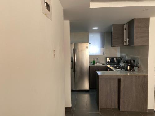 a kitchen with a stainless steel refrigerator and cabinets at Apartamento de tres habitaciones, dos baños,garaje, en ipiales nariño, cerca a la frontera con ecuador in Ipiales