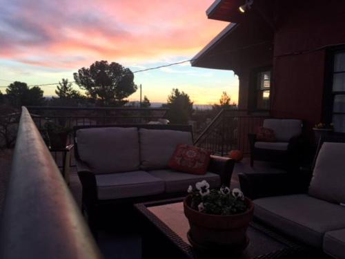 a patio with couches and a table and a sunset at Studio 203 in Clarkdale