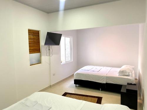 比亞維森西奧的住宿－IW-Apto en la vega, cerca al CC Viva，一间卧室设有两张床和窗户。