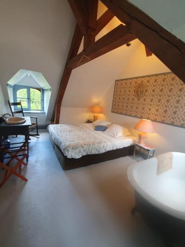 une chambre avec un lit, une table et une fenêtre dans l'établissement Cottages et B&B de Troussay, à Cheverny