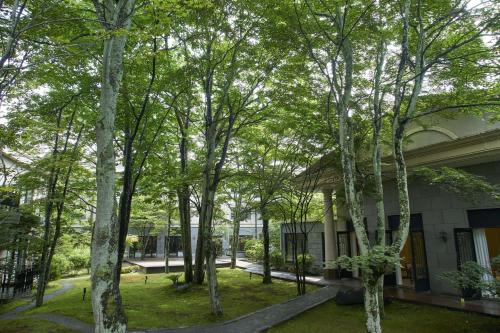 un grupo de árboles frente a un edificio en Kyukaruizawa Kikyo, Curio Collection by Hilton, en Karuizawa