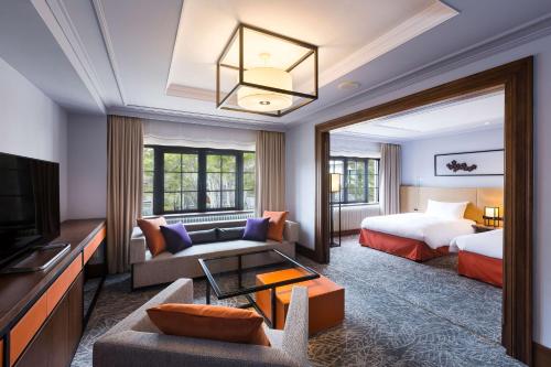 a hotel room with a bed and a living room at Kyukaruizawa Kikyo, Curio Collection by Hilton in Karuizawa