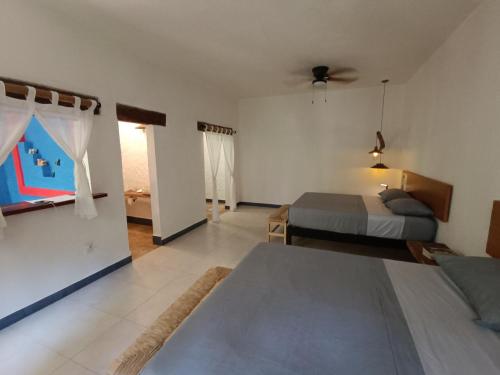 um quarto com uma cama e um quarto com duas camas em Jungle Lodge CANCUN AEROPUERTO em Cancún