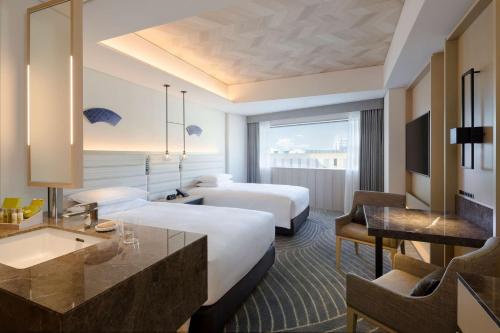 長崎市にあるヒルトン長崎のベッド2台とデスクが備わるホテルルームです。