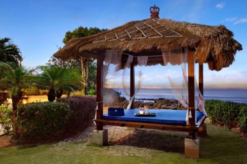 a gazebo with a bed with a view of the ocean at Hilton Guam Resort & Spa in Tumon