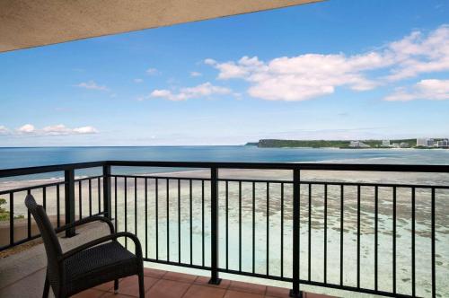 a chair on a balcony with a view of the ocean at Hilton Guam Resort & Spa in Tumon