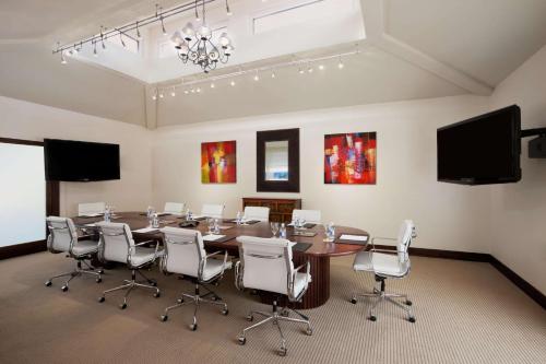 a conference room with a wooden table and white chairs at Hilton Guam Resort & Spa in Tumon