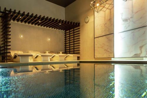a pool with a table and chairs in a building at Hilton Aberdeen TECA in Aberdeen