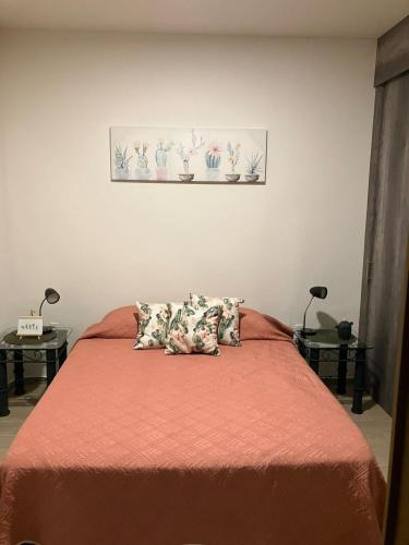 1 dormitorio con 1 cama con sábanas y almohadas de color naranja en Departamento lago de chapala con patio, en Jocotepec