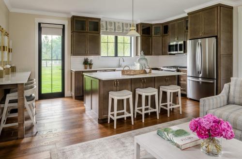 a kitchen with wooden cabinets and a kitchen island with bar stools at The Oaks Waterfront in Saint Michaels