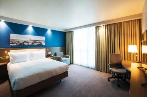 a hotel room with a bed and a desk and a chair at Hampton By Hilton Aberdeen Westhill in Westhill 