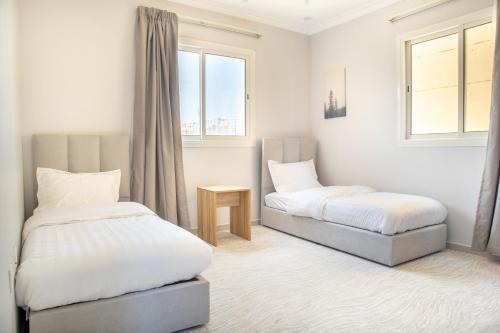 een slaapkamer met 2 bedden en een raam bij Luxury & Charming Big Apartments in Mudhainib in AR Rummanah