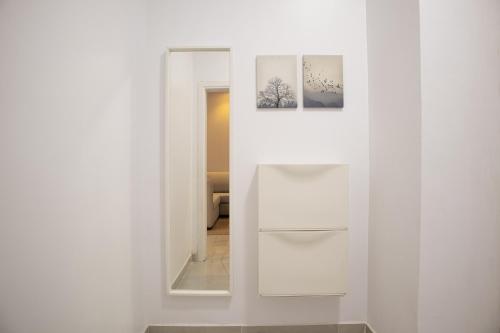 een witte kamer met een spiegel en een witte koelkast bij Luxury & Charming Big Apartments in Mudhainib in AR Rummanah