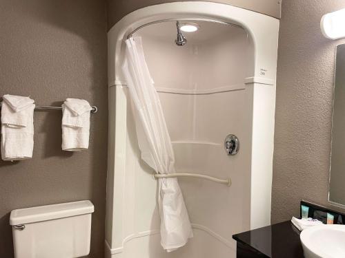 a bathroom with a shower with a toilet and a sink at Motel 6 Cheyenne in Cheyenne