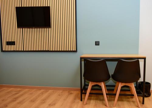 two chairs sitting at a table with a television at Kraka Apartments in Leonidion