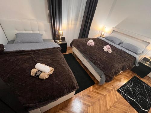 two beds in a hotel room with pink hello kitty pillows at Apartman Žanić Ogulin in Ogulin