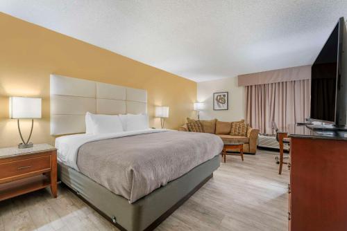a hotel room with a bed and a living room at Quality Inn Alamosa in Alamosa