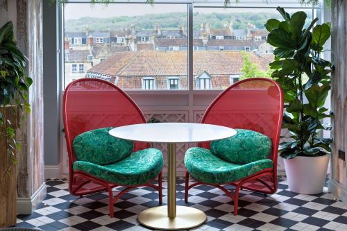 a table and two chairs in a room with a window at DoubleTree by Hilton Bath in Bath