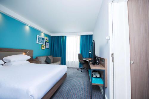 a hotel room with a large bed and a desk at Hampton By Hilton Belfast City Centre in Belfast