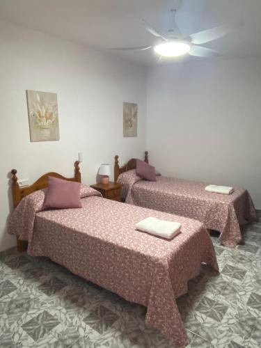 Habitación con 2 camas y techo. en Casa “El Zumaque” en Zahara de la Sierra, en Zahara de la Sierra