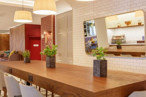 a dining room with a table with chairs and a mirror at DoubleTree by Hilton Bath in Bath