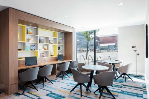 une salle de réunion avec des tables et des chaises ainsi qu'une fenêtre dans l'établissement Hampton By Hilton Belfast City Centre, à Belfast