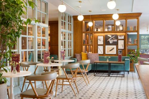 a restaurant with tables and chairs and a couch at DoubleTree by Hilton Bath in Bath