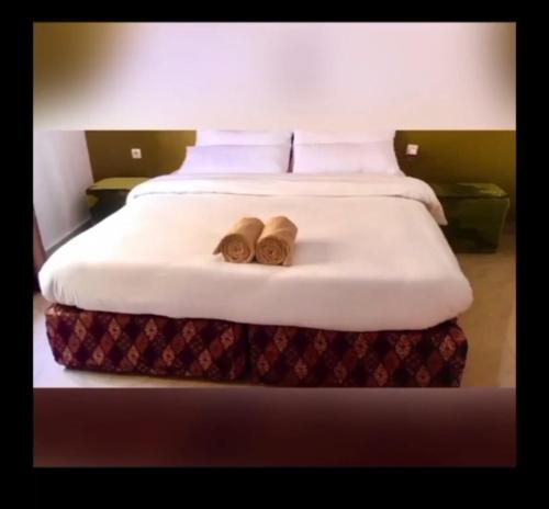 a bed with two wooden slippers on top of it at Maisondulac7 in Rubavu