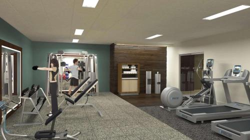 a gym with treadmills and machines in a room at DoubleTree by Hilton Bath in Bath