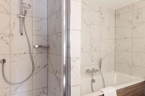 a bathroom with a shower and a tub and a sink at DoubleTree by Hilton Bath in Bath