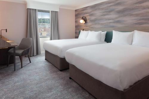 a hotel room with two beds and a desk at DoubleTree by Hilton Bath in Bath
