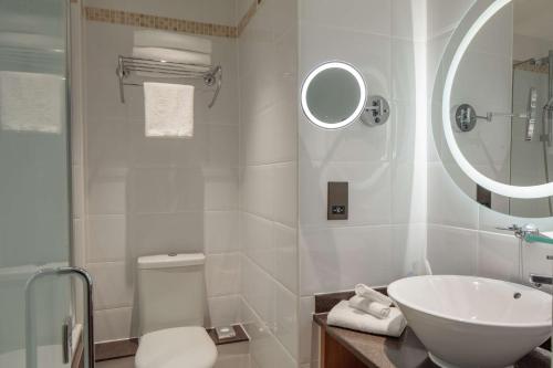 a bathroom with a sink and a toilet and a mirror at DoubleTree by Hilton Bath in Bath