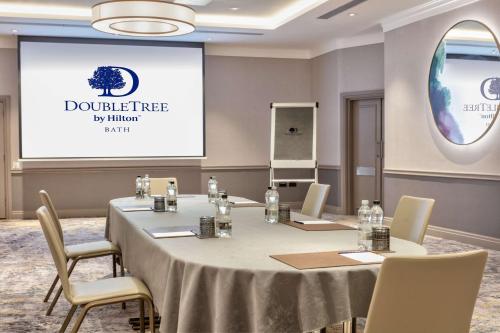 a meeting room with a table and a projector screen at DoubleTree by Hilton Bath in Bath