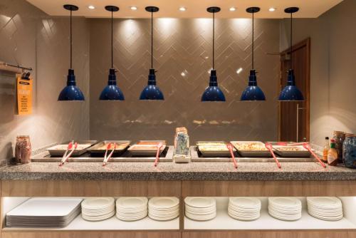 a buffet line with white plates and blue vases at Hampton by Hilton Birmingham Jewellery Quarter in Birmingham