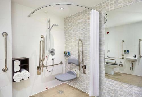 a bathroom with a shower and a toilet and a sink at Hampton by Hilton Bournemouth in Bournemouth