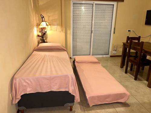 two beds in a room with a window at Departamento Céntrico in Goya