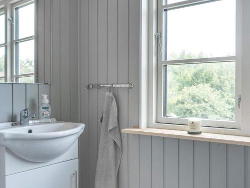 een witte badkamer met een wastafel en een raam bij Holiday home Bindslev XVI in Bindslev