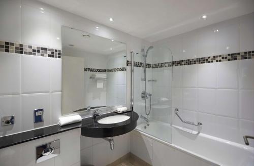 y baño blanco con lavabo y ducha. en DoubleTree by Hilton Bristol North en Bristol