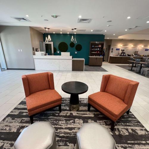 eine Lobby mit 2 Stühlen, einem Tisch und einer Theke in der Unterkunft Best Western San Bernardino Hotel in San Bernardino