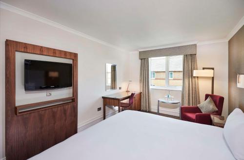 a hotel room with a bed and a flat screen tv at DoubleTree by Hilton Bristol North in Bristol