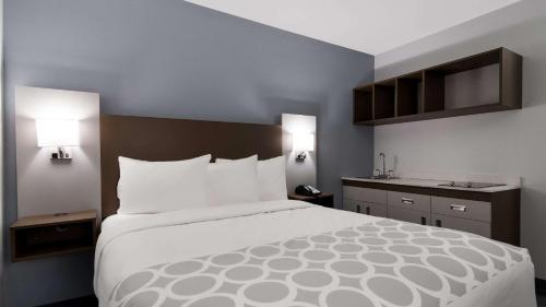 a large bed in a hotel room with two lamps at Suburban Studios Portage in Portage