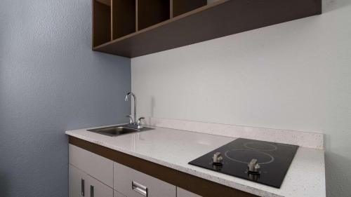 a kitchen with a sink and a counter top at Suburban Studios Portage in Portage