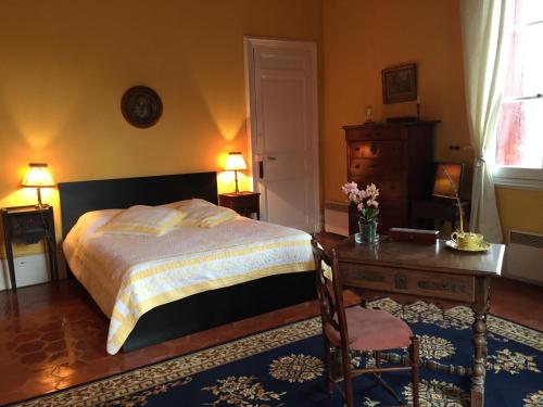 une chambre avec un lit, un bureau et une table dans l'établissement La Bellonette, à Marseillan