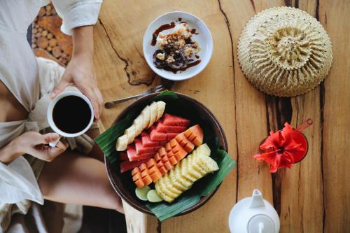 Villa Campuhan في Jasri: طاولة مع طبق من الطعام وكوب من القهوة