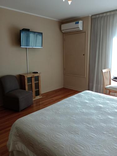 1 dormitorio con 1 cama, 1 silla y 1 ventana en MZA Departamentos en Mendoza