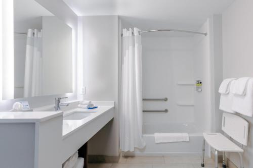 a white bathroom with a shower and a sink at Holiday Inn Express Calhoun South by IHG in Calhoun