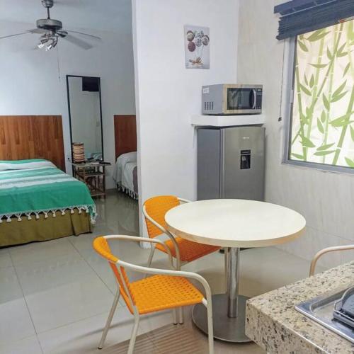 a room with a table and chairs and a bed at Departamento 5 Los Corales (tipo estudio) in Mezcales